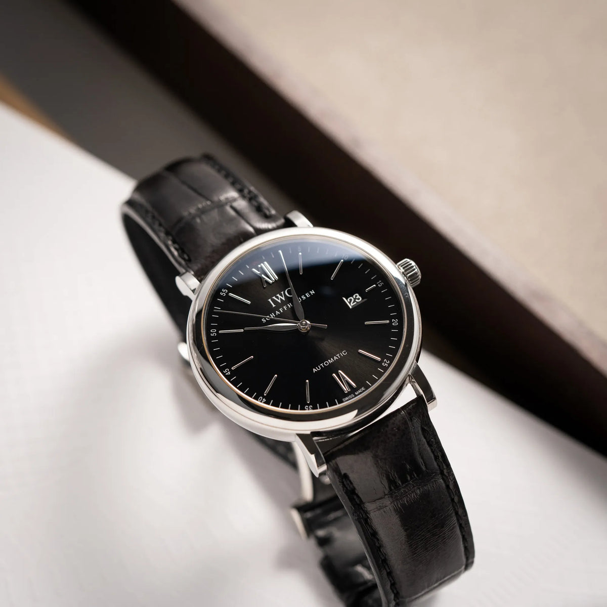 Produktfotografie der IWC Portofino 40 Automatik Armbanduhr mit schwarzem Zifferblatt am schwarzen Lederband