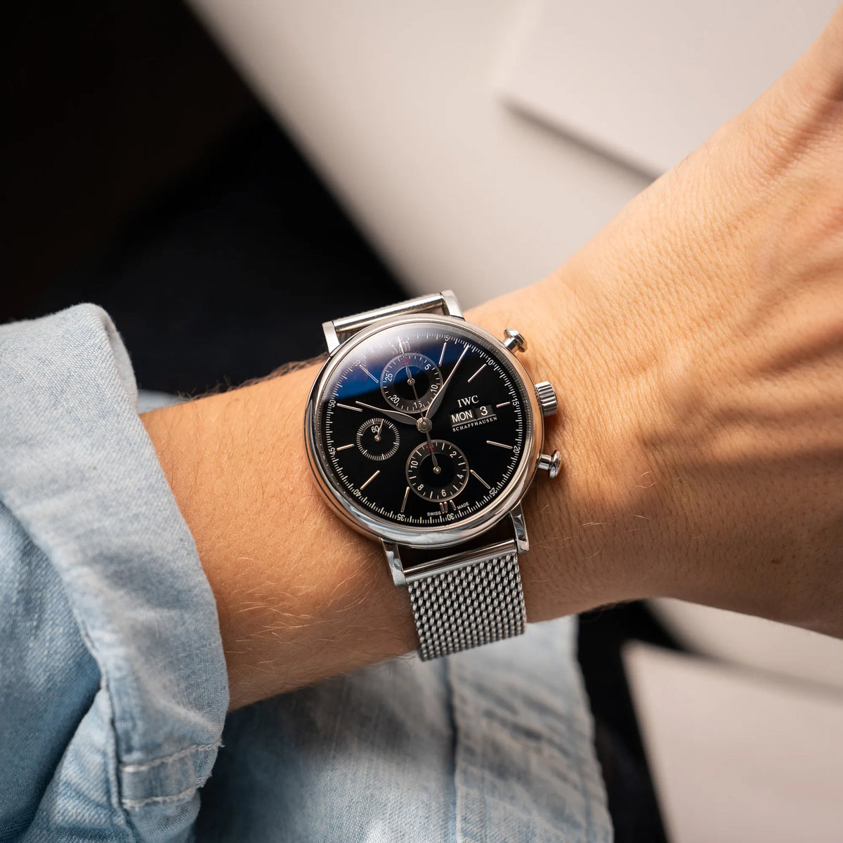 Wristshot mit dem IWC Portofino Chronograph der Referenz IW391002 mit schwarzem Zifferblatt an einem Mesh-Armband an einem Mnnerhandgelenk