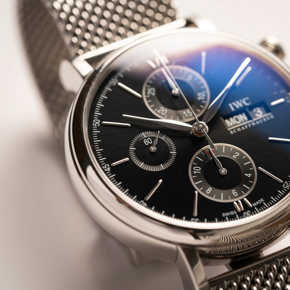 Nahaufnahme des IWC Portofino Chronograph der Referenz IW391002 mit schwarzem Zifferblatt an einem Mesh-Armband mit Fokus auf der kleinen Sekunde bei 9 Uhr
