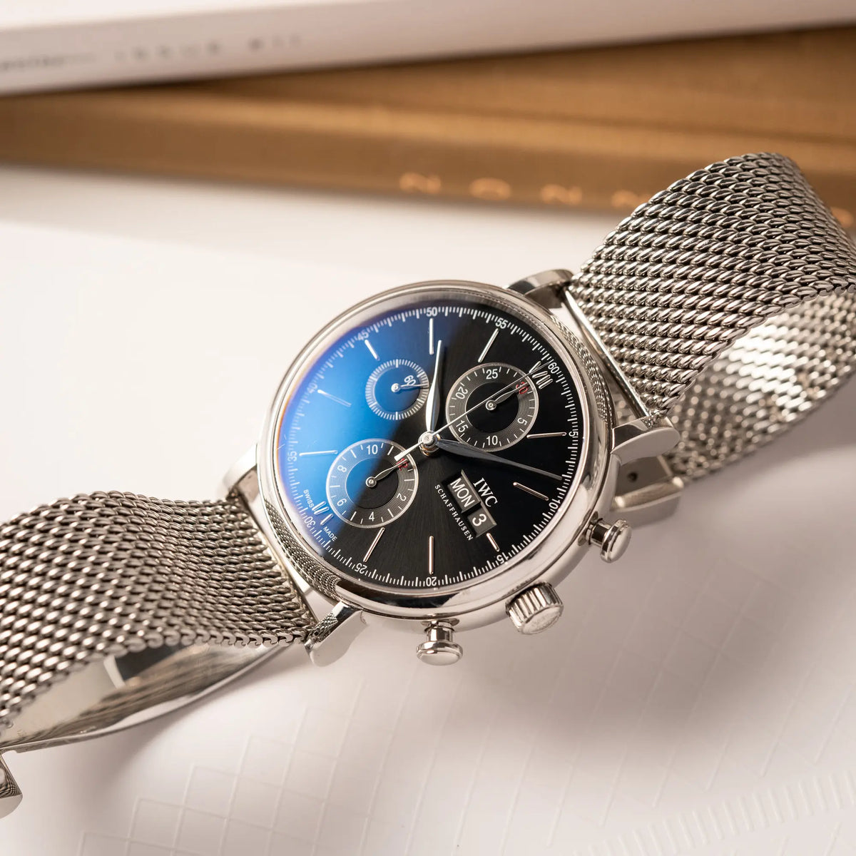 Produktfoto des IWC Portofino Chronograph der Referenz IW391002 mit schwarzem Zifferblatt an einem Mesh-Armband