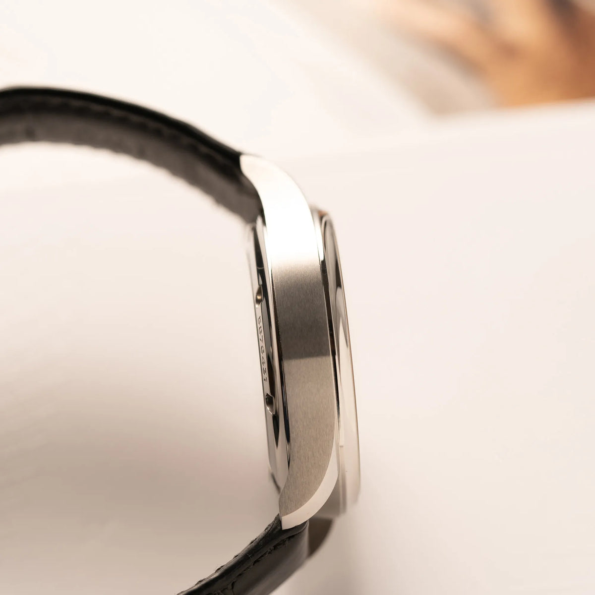 Seitliche Gehäuseflanke der IWC Portugieser 40 Automatik IW358303 mit weißem Zifferblatt und roségoldenen Zeiger- und Index-Details am schwarzen Lederband