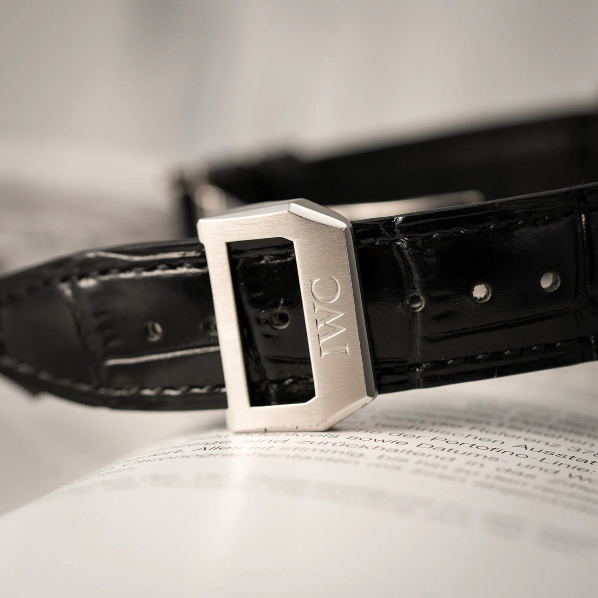Detailaufnahme der IWC-Faltschliesse der IWC Portugieser 7 Days IW500109 mit schwarzem Zifferblatt am schwarzen Lederband