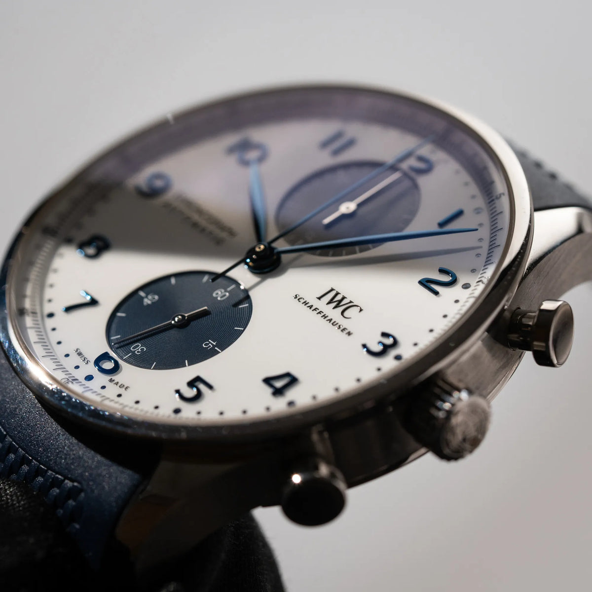 Produktfoto der IWC Portugieser Chronograph 41 der Referenz IW371620 mit weißem Zifferblatt und dunkelblauen Totalisatoren am passenden dunkelblauen Kautschukarmband