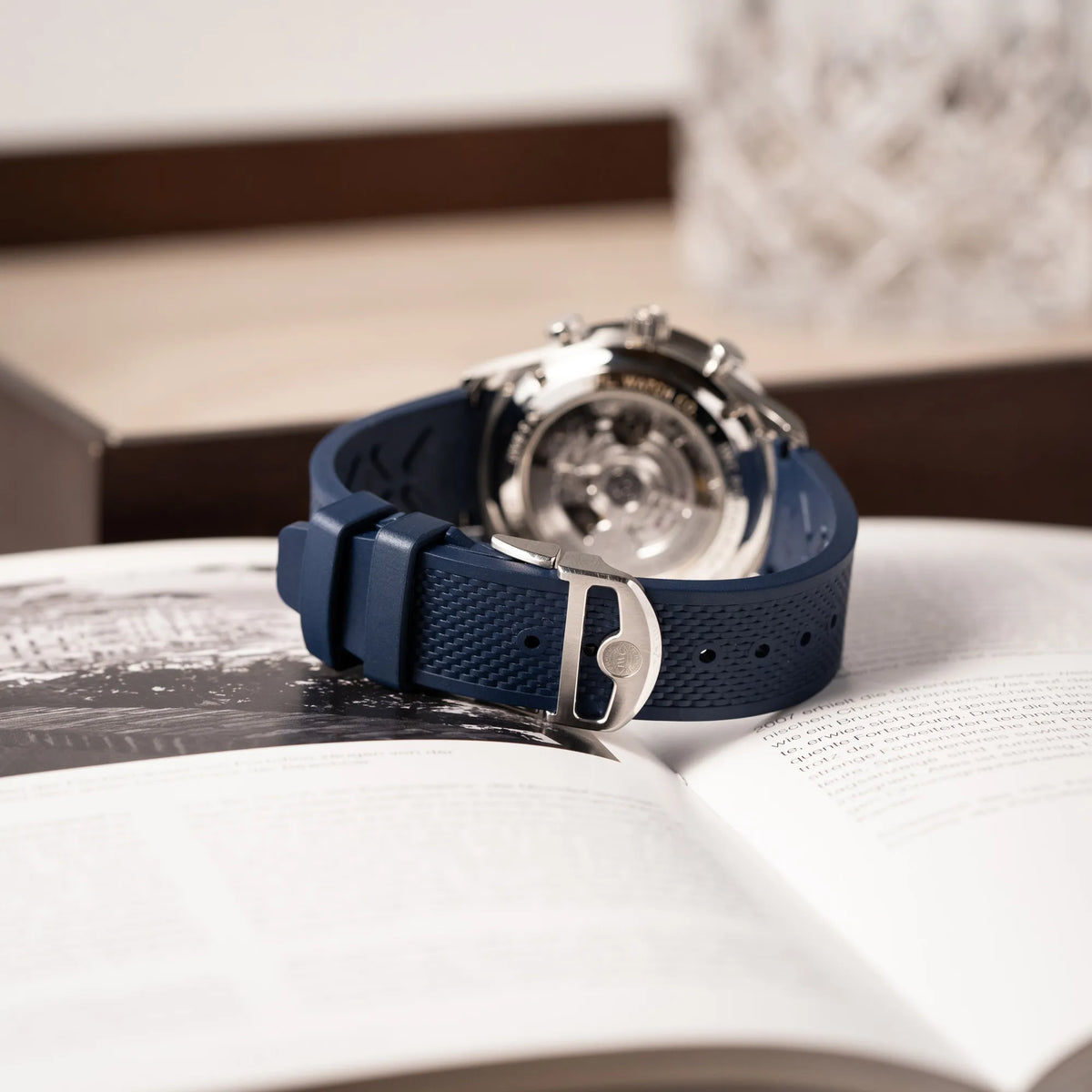Produktfotografie zeigt die geschlossene Faltschliesse der IWC Portugieser Chronograph 41 der Referenz IW371620 mit weißem Zifferblatt und dunkelblauen Totalisatoren am passenden dunkelblauen Kautschukarmband
