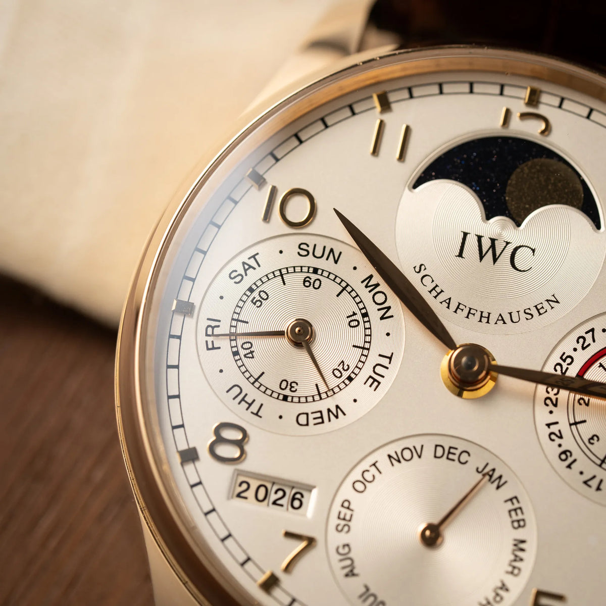 Detailaufnahme mit Fokus auf dem Hilfszifferblatt bei 9 Uhr zur Anzeige des Wochentags und der Sekunde des Portugieser Ewiger Kalender IW502213 von IWC in einem 42mm-Rosegold-Gehäuse am braunem IWC Lederband mit einem sanften weißem Zifferblatt