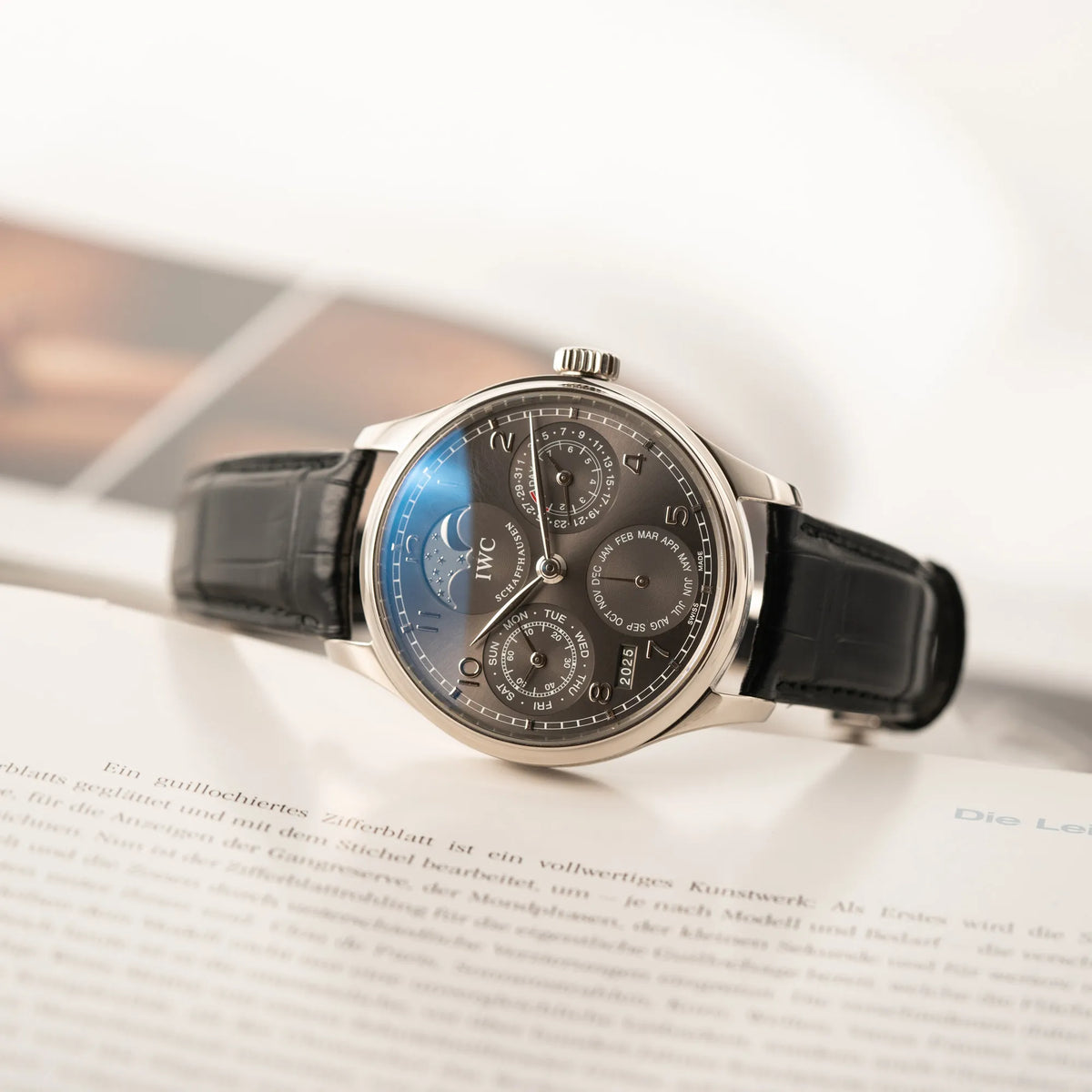 Produktfotografie des seitlich auf dem Uhrengehäuse liegenden IWC Portugieser Ewiger Kalender IW502307 mit 44m Weißgold-Gehäuse und anthrazit-farbenem Zifferblatt