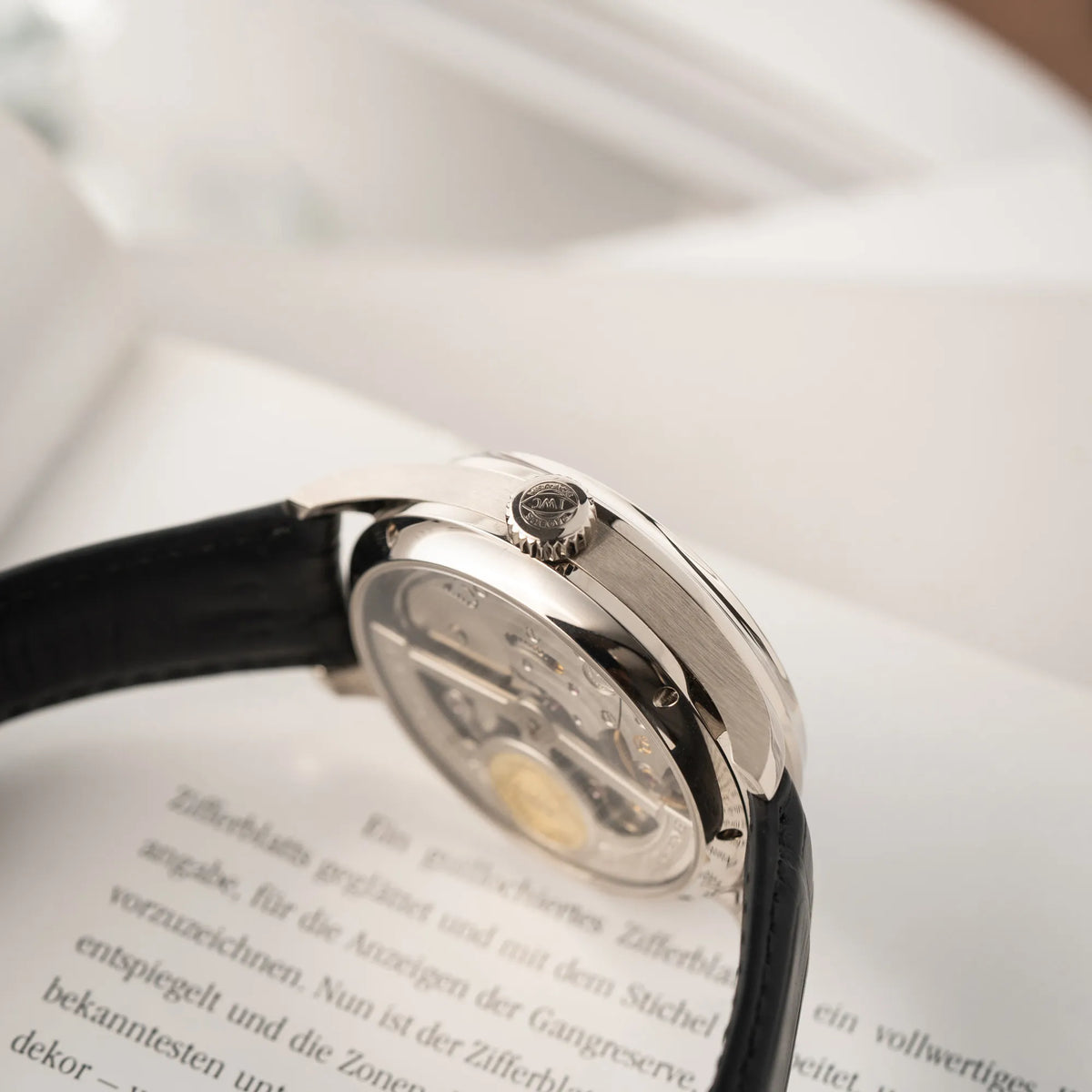 Produktfotografie des IWC Portugieser Ewiger Kalender IW502307 mit 44m Weißgold-Gehäuse und anthrazit-farbenem Zifferblatt mit Fokus auf der Aufzugskrone