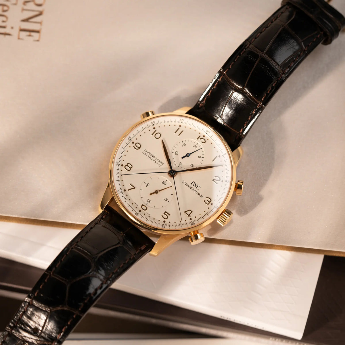 Produktfotografie als Titelbild für die IWC Portugieser Rattrapante Doppel-Chronograph IW3712 aus 18k Roségold mit weißem Zifferblatt am braunen Lederband