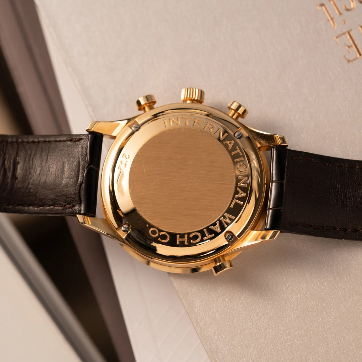 Produktfotografie des IWC Portugieser Rattrapante Doppel-Chronograph IW3712 aus 18k Roségold mit weißem Zifferblatt am braunen Lederband zeigt den Gehäuseboden