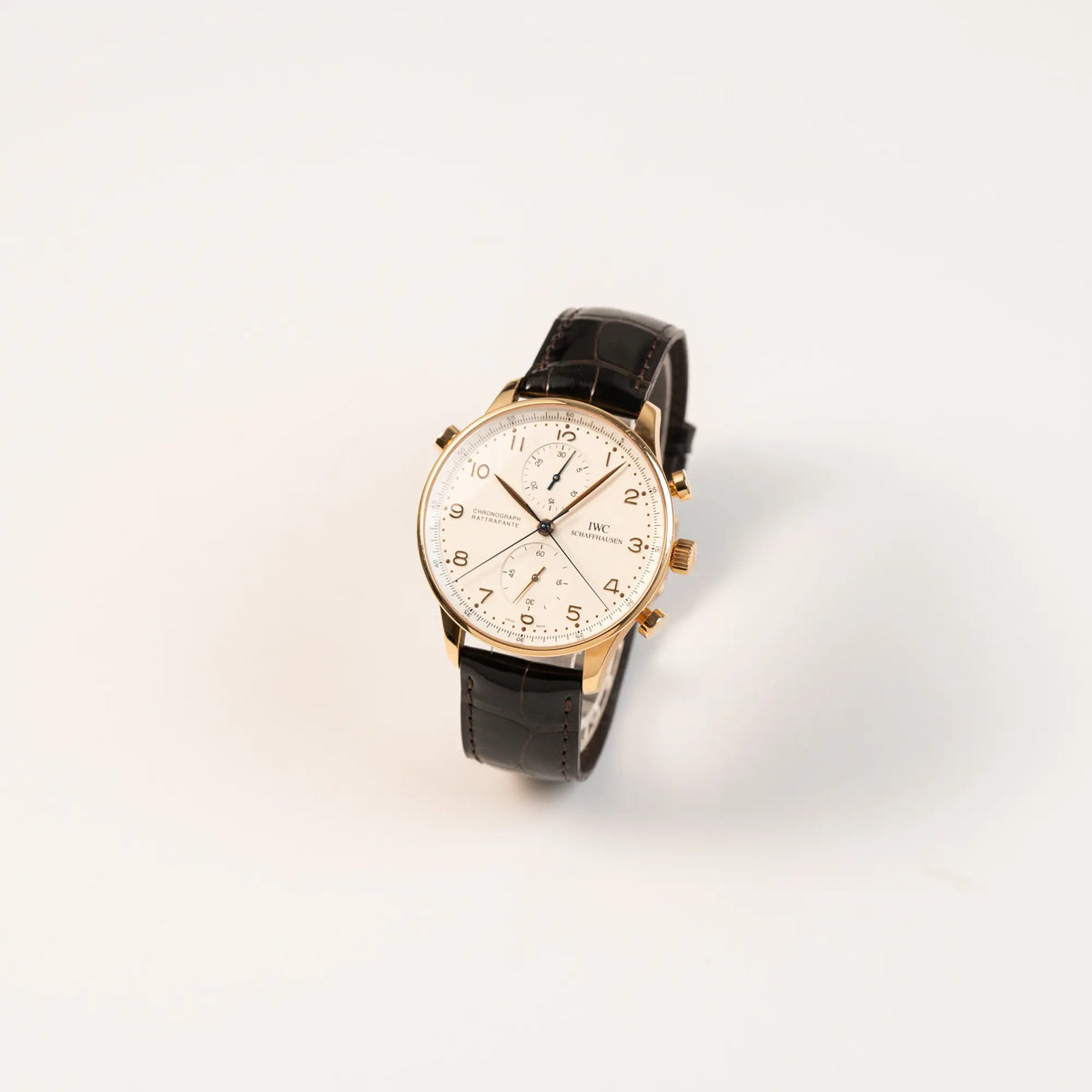 Leicht schräge Ansichtt des IWC Portugieser Rattrapante Doppel-Chronograph IW3712 aus 18k Roségold mit weißem Zifferblatt am braunen Lederband