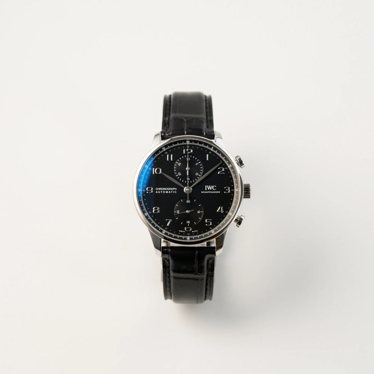 Frontale Ansicht der IWC Portugieser Chronograph Uhr mit schwarzem Zifferblatt an einem schwarzen Lederband