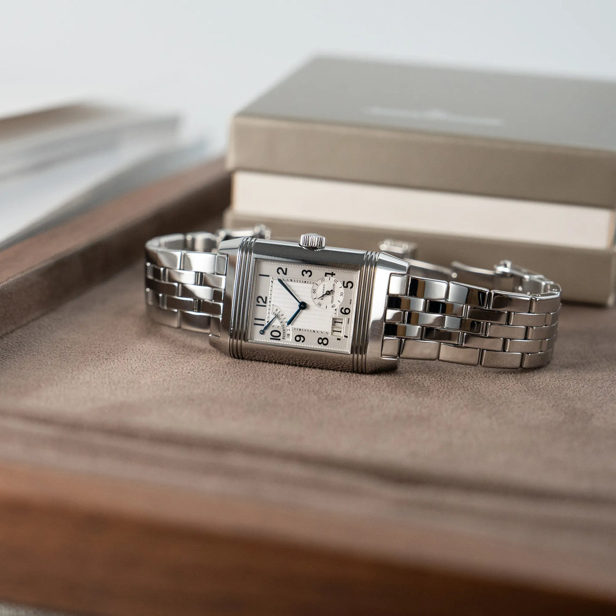Produktfotografie der Jaeger LeCoultre Reverso Grand Date Armbanduhr auf einem hellbraunen Juweliers-Tablet