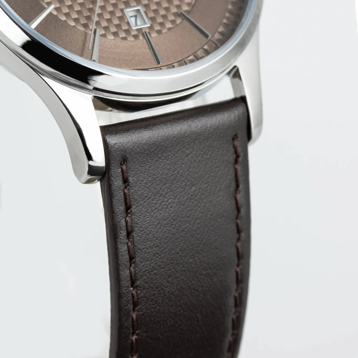 Unterer Bandanstoß der Jacques Lemans 1-2193K Derby Armbanduhr mit Tages und Datumsanzeige, welche farblich abgestimmt ist durch ein bronzefarbenes Zifferblatt und ein braunes Lederband