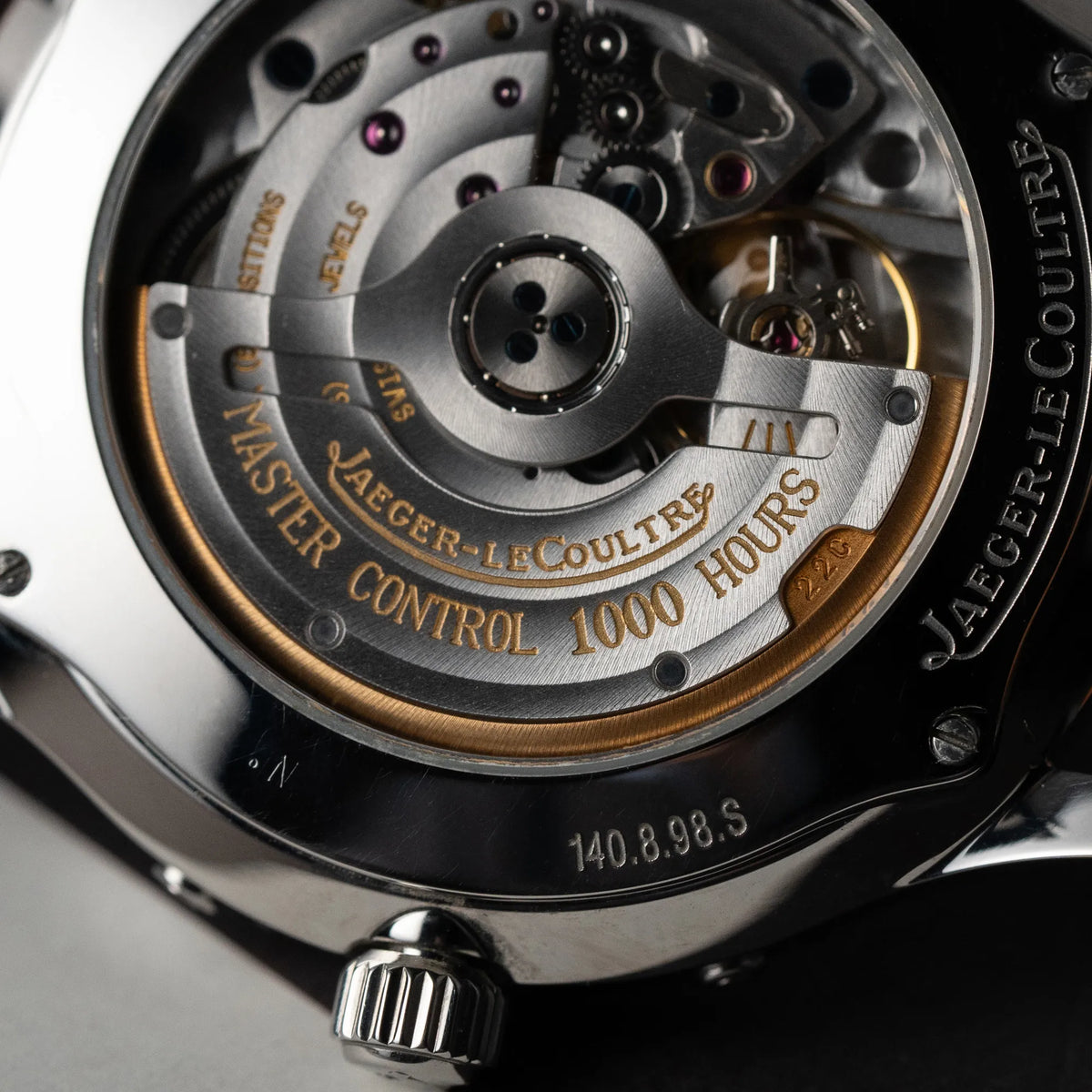 Makroaufnahme des Calibers 891 der Jaeger LeCoultre Master Control Calender Moonphase mit silbernem Zifferblatt an einem braunen JLC-Lederband durch den Glasboden