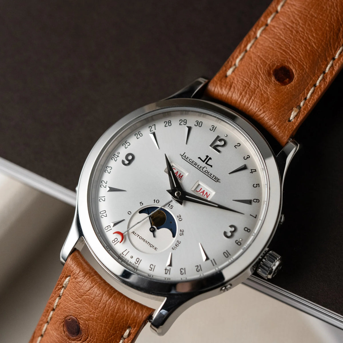 Detailaufnahme der Jaeger LeCoultre Master Control Calender Moonphase mit silbernem Zifferblatt an einem braunen JLC-Lederband