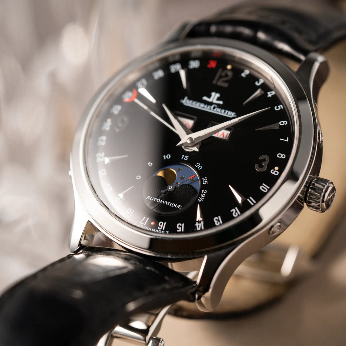 Detailaufnahme der Jaeger-LeCoultre Master Control Moonphase Calendar mit schwarzem Zifferblatt am schwarzen Lederband