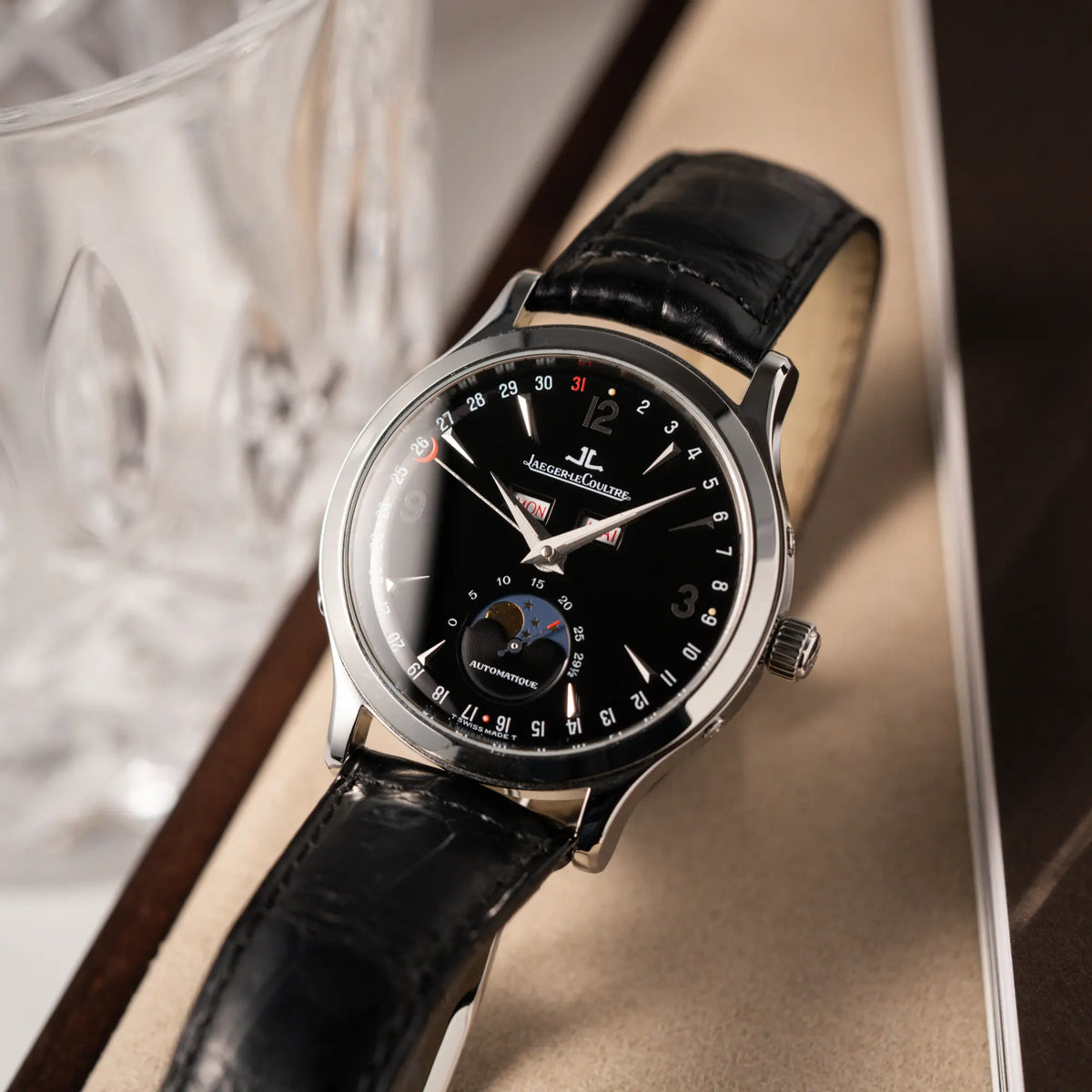 Produktfotografie der Jaeger-LeCoultre Master Control Moonphase Calendar am schwarzen Lederband zeigt die Beschaffenheit des tiefschwarzen Zifferblatts