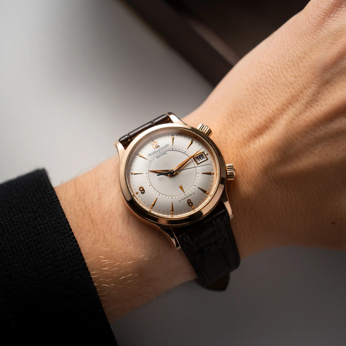 Mann trägt die Jaeger-LeCoultre Master Memovox 141.2.97 Armbanduhr in Rosegold mit braunem Lederband am Arm