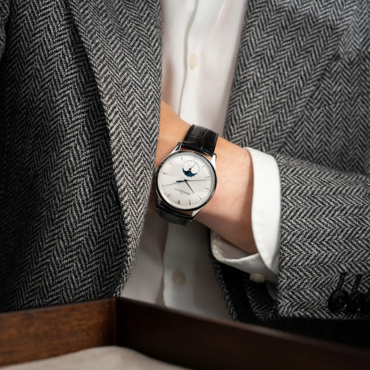 Mann hat die Jaeger-LeCoultre Master Ultra Thin mit Mondphase der Referenz 176.8.64.S mit weiß-silbernem Zifferblatt an seinem Handgelenk