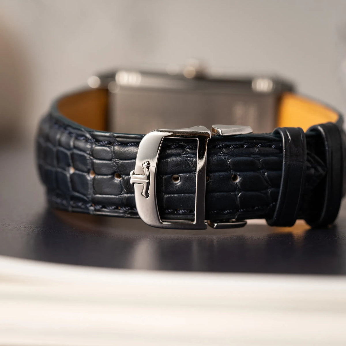 Detailaufnahme der silberfarbenen JLC_Faltschliesse am dunkelblauen Lederband von der Jaeger-LeCoultre Grande Reverso Calendar 273.8.84 
