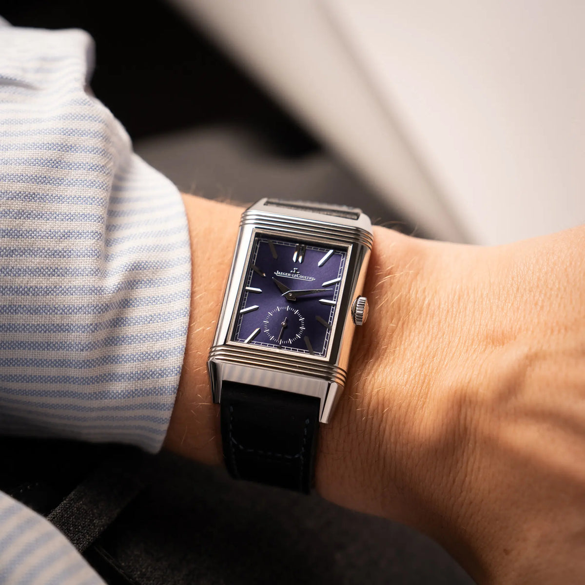 Wristshot mit der Jaeger-LeCoultre Reverso Duoface Q3988482 mit blauem Zifferblatt und weißem Night-and-Day-Zifferblatt am schwarzen Lederband