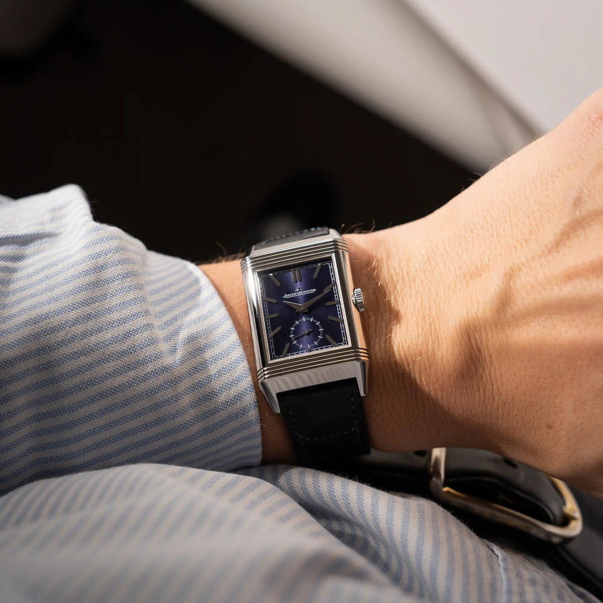 Mann trägt die Jaeger-LeCoultre Reverso Duoface Q3988482 mit blauem Zifferblatt und weißem Night-and-Day-Zifferblatt am schwarzen Lederband