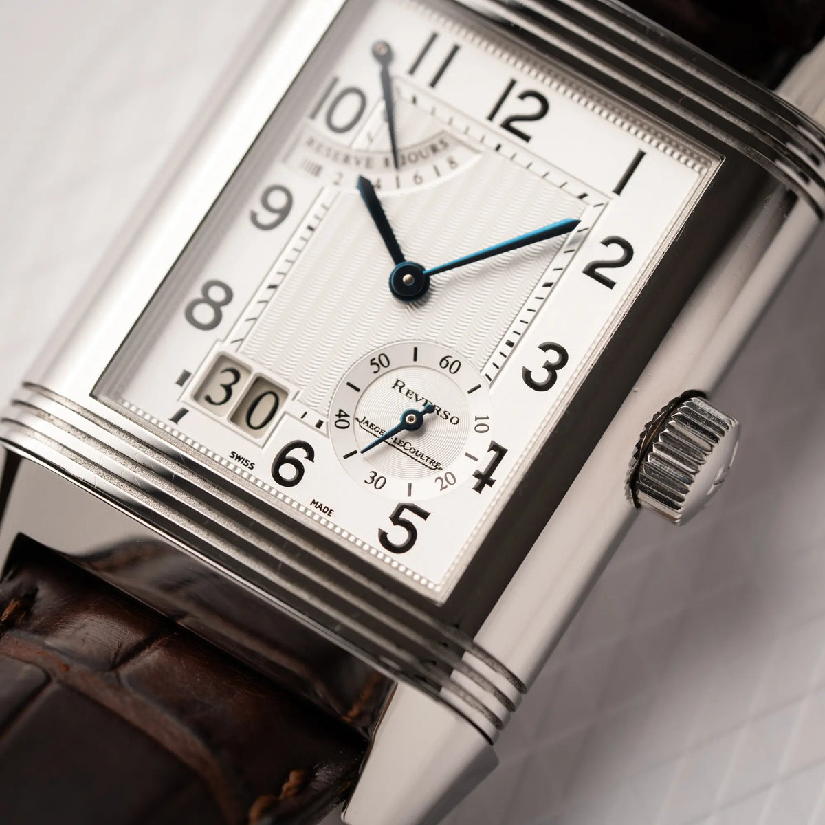 Detailaufnahme mit Fokus auf der kleinen Sekunde von der Jaeger-LeCoultre Reverso Grande Date der Referenz 240.8.15 mit silberfarbenem Zifferblatt und Großdatums-Anzeige, kleiner Sekunde und Gangreserve-Anzeige am braunen Lederband