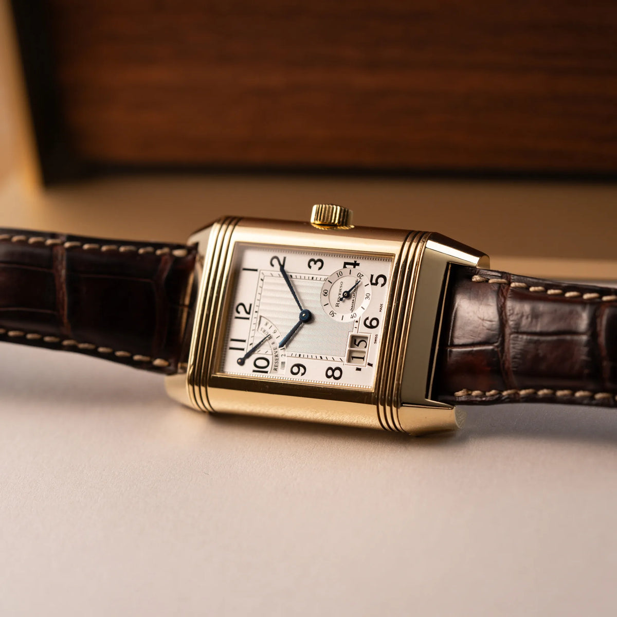 Produktfotografie der Jaeger-LeCoultre Reverso Grande Date der Referenz 240.1.15 mit einem Gelbgold-Gehäuse am braunen Lederband