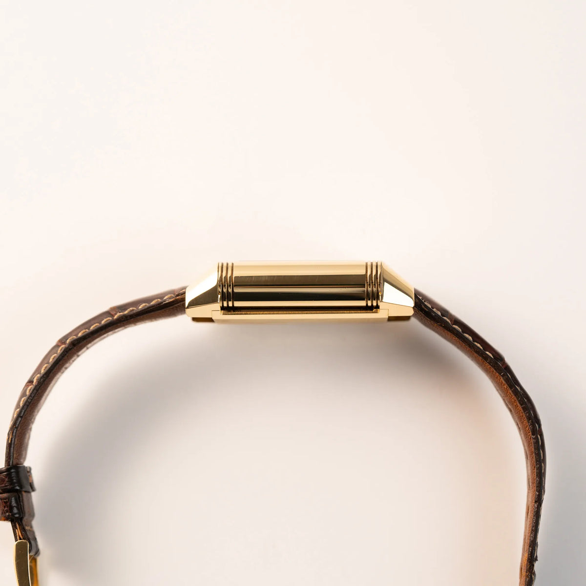 Seitliches Gehäuse der Jaeger-LeCoultre Reverso Grande Date der Referenz 240.1.15 mit einem Gelbgold-Gehäuse am braunen Lederband