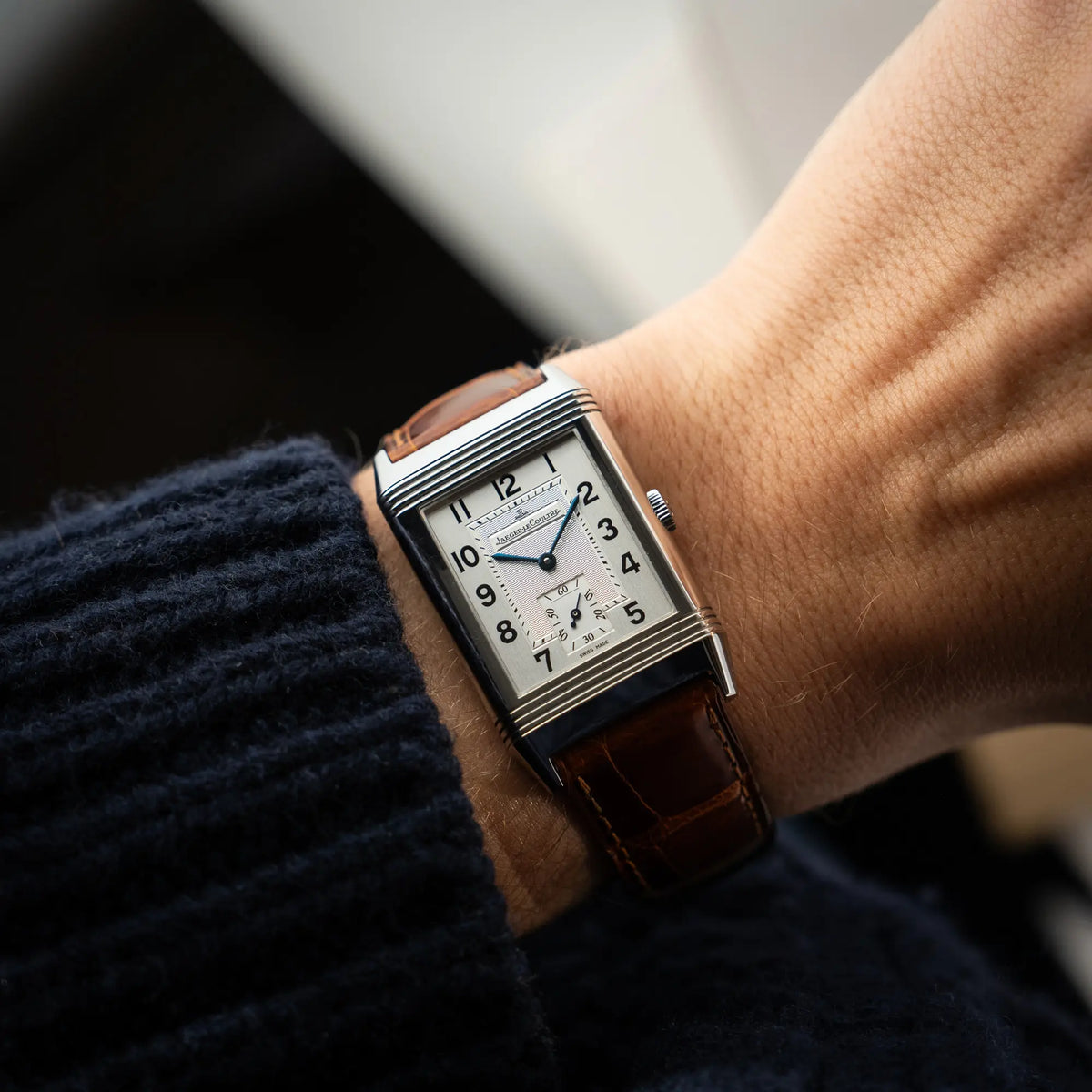 Mann trägt die Jaeger-LeCoultre Reverso Grande Taille der Referenz 270.8.62 mit einem teil-guillochiertem, silberfarbenem Zifferblatt an einem braunem Lederband an seinem Handgelenk