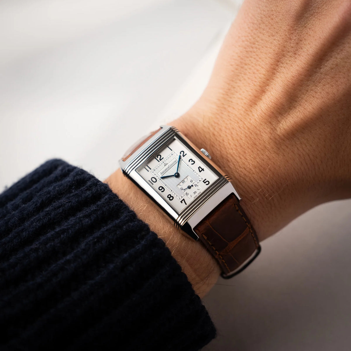 Mann trägt die Jaeger-LeCoultre Reverso Grande Taille der Referenz 270.8.62 mit einem teil-guillochiertem, silberfarbenem Zifferblatt an einem braunem Lederband