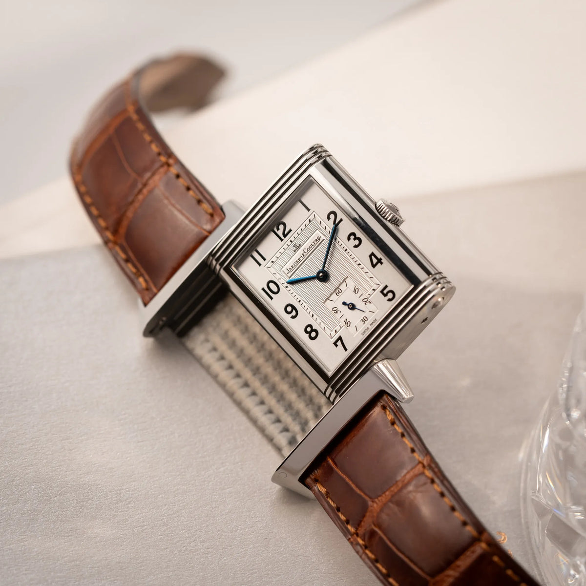 Produktfotografie als Titelbild für die Jaeger-LeCoultre Reverso Grande Taille der Referenz 270.8.62 mit einem teil-guillochiertem, silberfarbenem Zifferblatt an einem braunem Lederband
