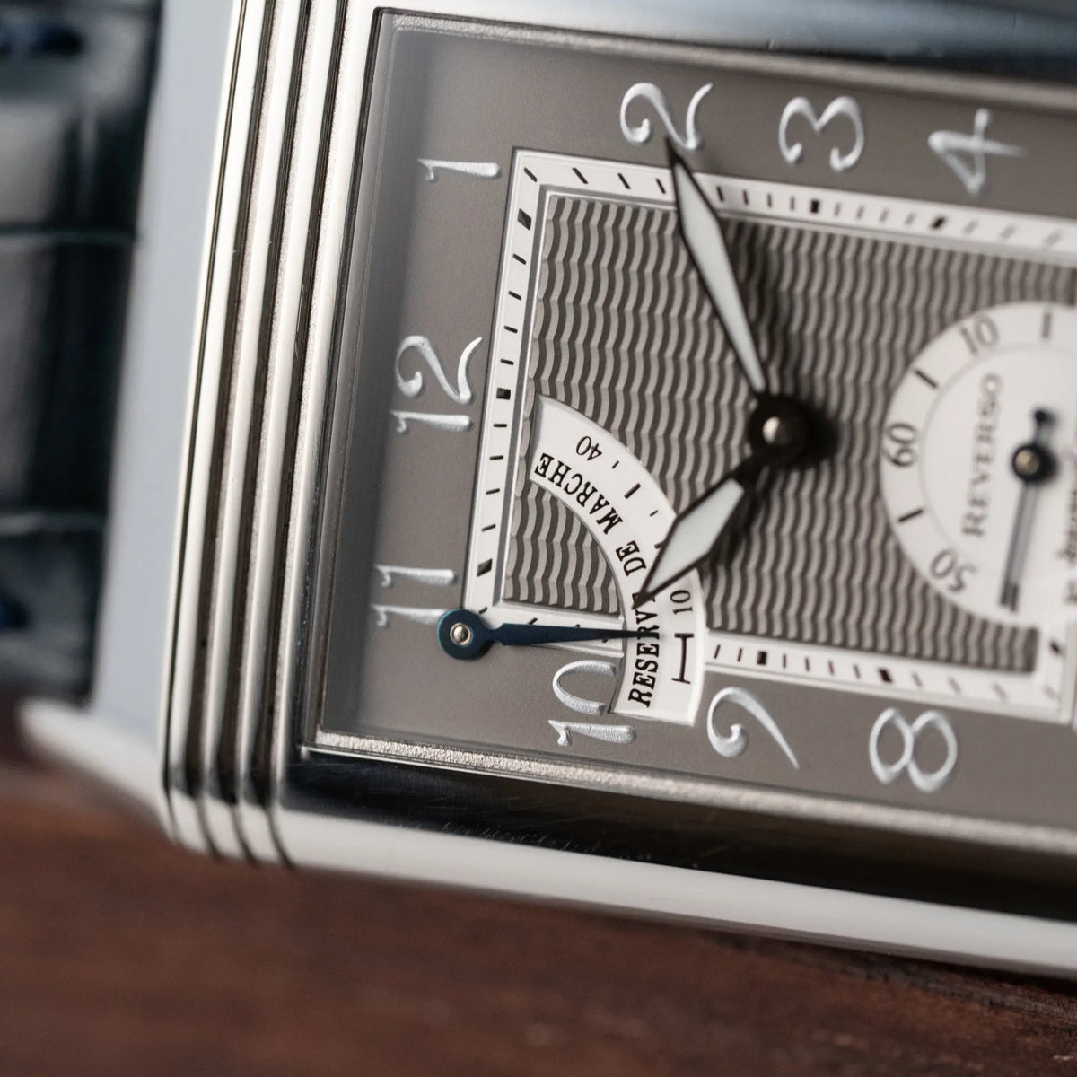 Detailaufnahme der Jaeger LeCoultre Reverso "Reserve de Marche" mit Platingehäuse am Lederband mit Fokus auf der Anzeige bei 11 Uhr