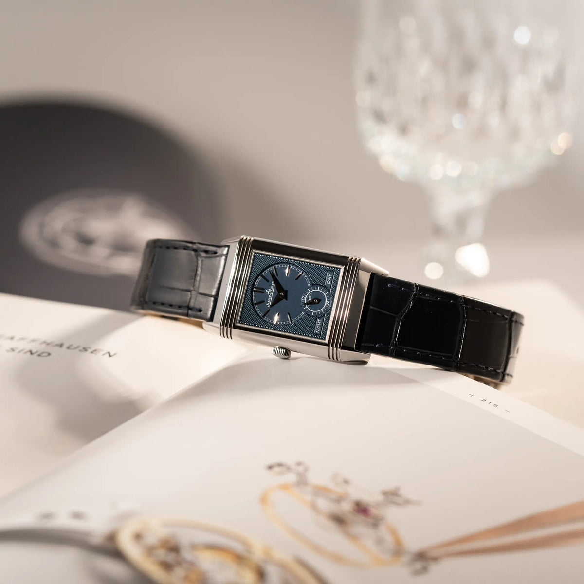 Produktfotografie der Jaeger-LeCoultre Reverso Tribute Duoface Q3908420 mit blauem Day&Night-Zifferblatt an einem dunkelblauen Lederband