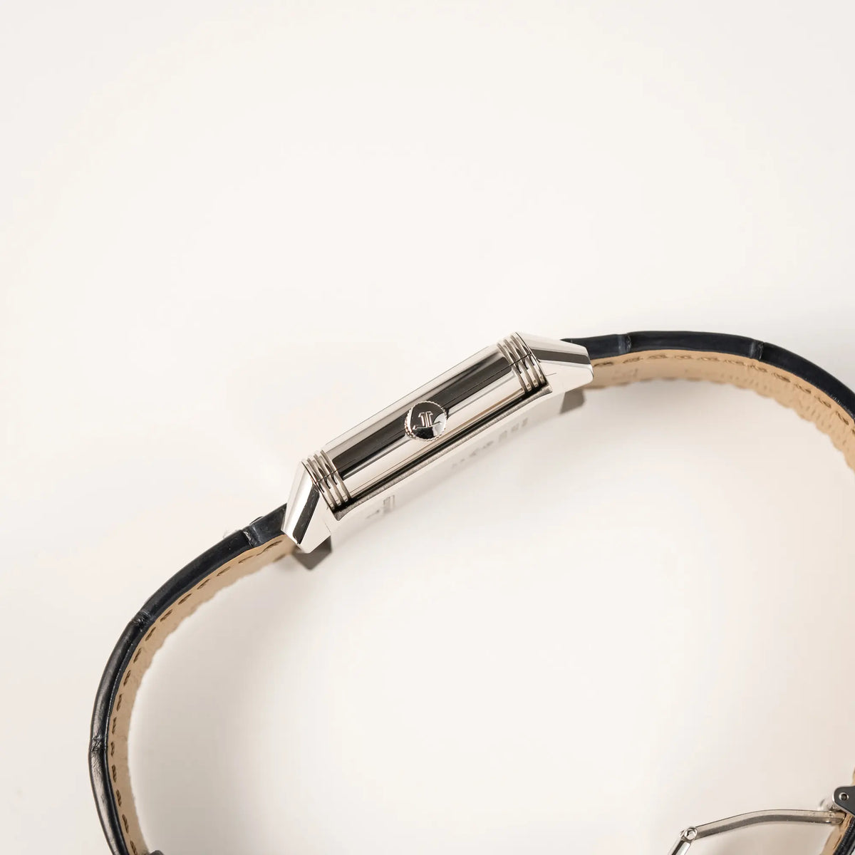 Seitliche Gehäuseflanke mit Aufzugskrone von der Jaeger-LeCoultre Reverso Tribute Duoface Q3908420 an einem dunkelblauen Lederband