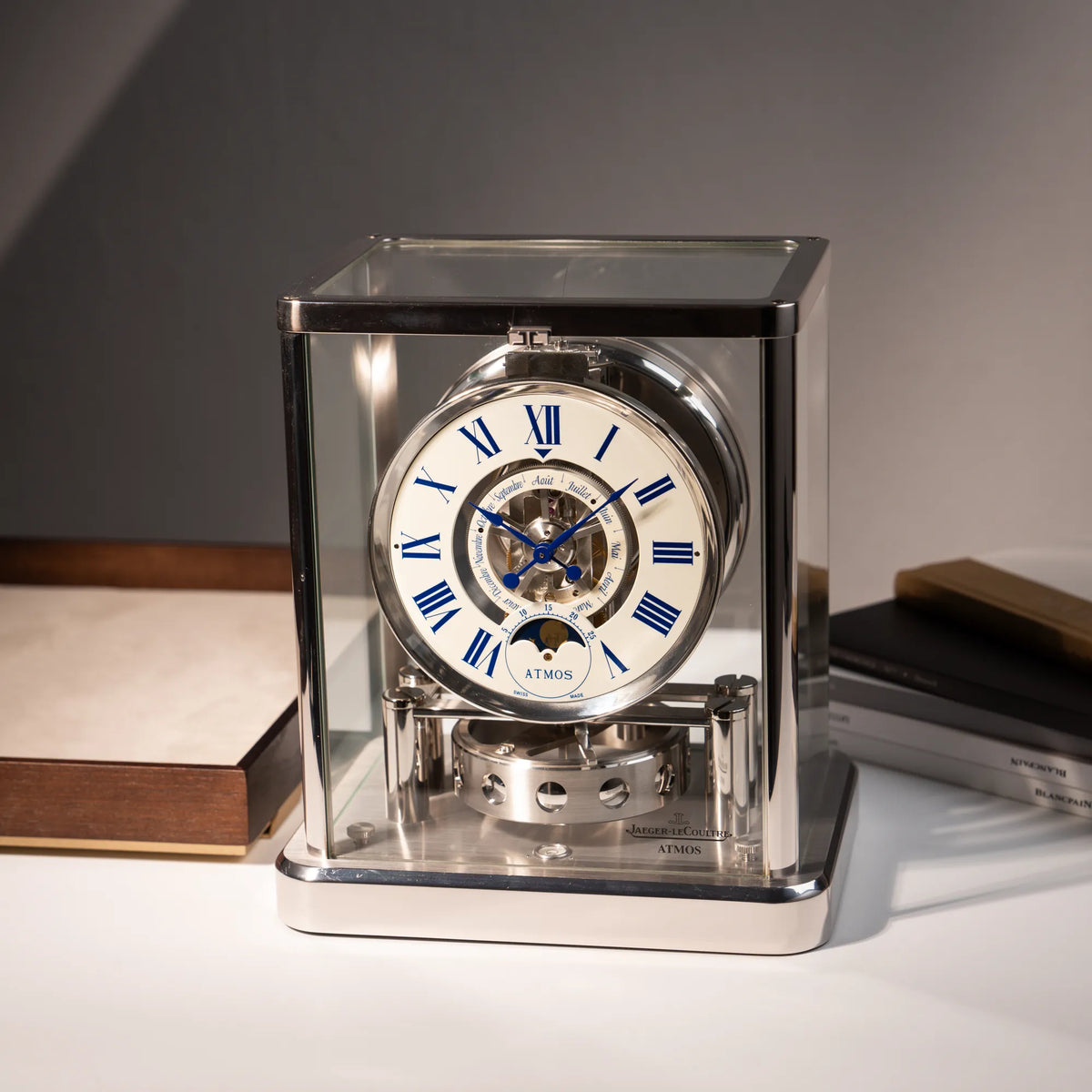 Fotografie der  Jaeger-LeCoultre Atmos Mondphase Tischuhr in rhodiniertem Stahl mit weißem Zifferblatt und blauen römischen Indizes