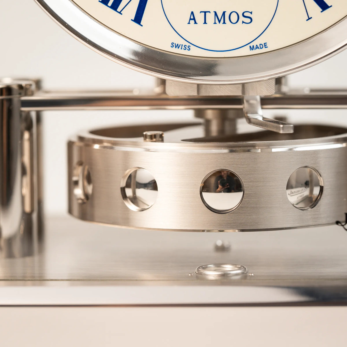 Detailaufnahme der Perpetuum Mobile Uhrwerks der Jaeger-LeCoultre Atmos Mondphase Tischuhr in rhodiniertem Stahl mit weißem Zifferblatt und blauen römischen Indizes