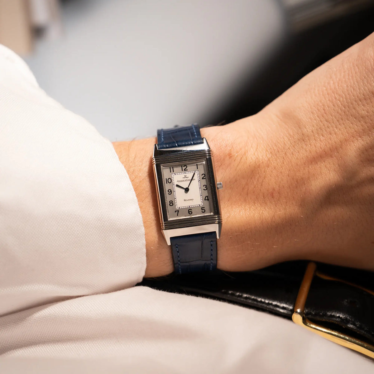 Mann trägt die Jaeger-LeCoultre Reverso Classique Medium 250.8.86 in Edelstahl an einem dunkelblauem Lederband an seinem Handgelenk