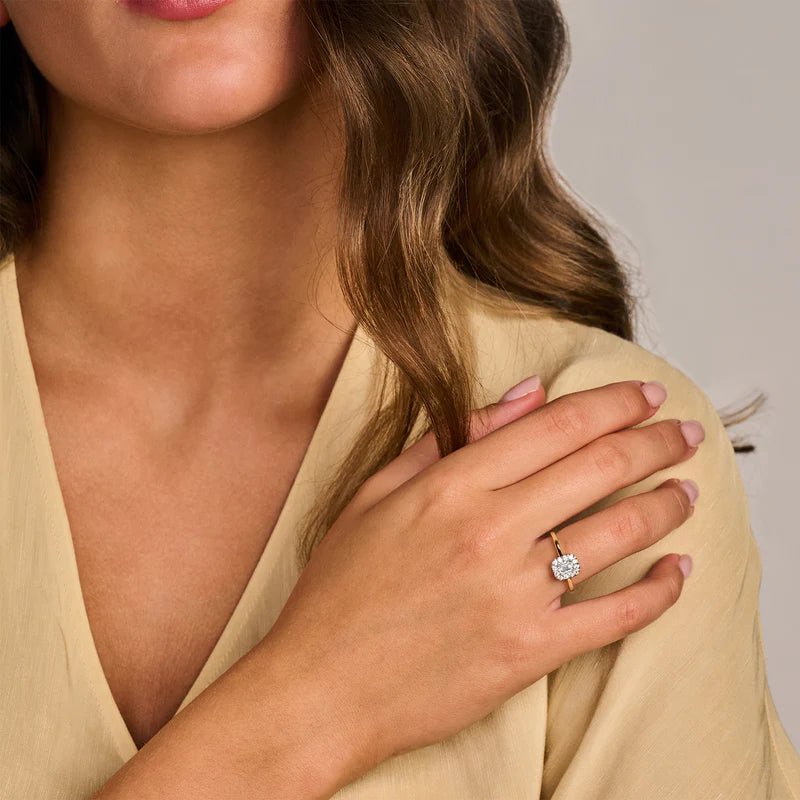 Model trägt einen Damenring von Blush Jewels an ihrem Ringfinger, welcher aus 14 karätigem Gelbgold mit einer minimalistischen Ringschiene gefertigt wurde und einem zentralen rechteckigem Labor-Diamant, welcher von einem Diamantkranz umrandet ist