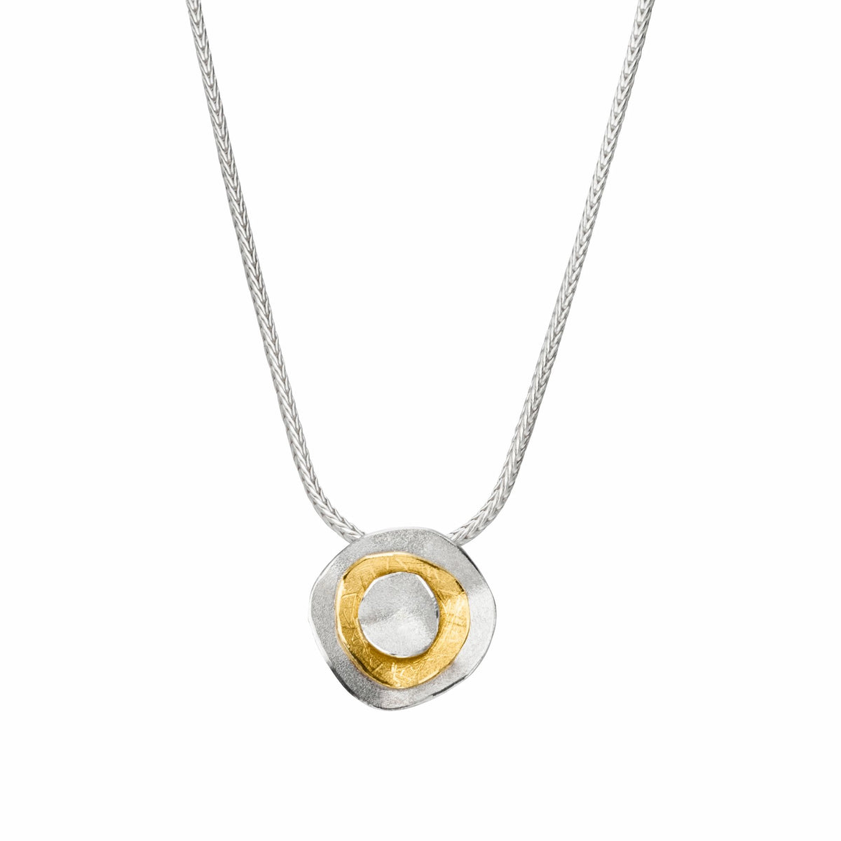 Halskette von Manu Schmuck mit einem silber-goldenen Anhänger, der in seiner Form an eine Blüte erinnert