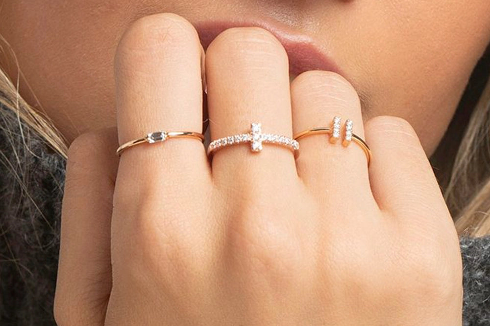 Frau präsentiert drei Marina Garcia Ringe aus Gelbgold mit Brillanten an Ihrer Hand