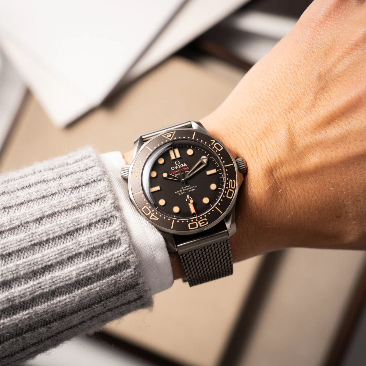 Mann trägt die Omega Seamaster 300m Diver No Time To Die Limited Edition aus Titan mit braunem Zifferblatt für einen Wristshot an seinem Handgelenk