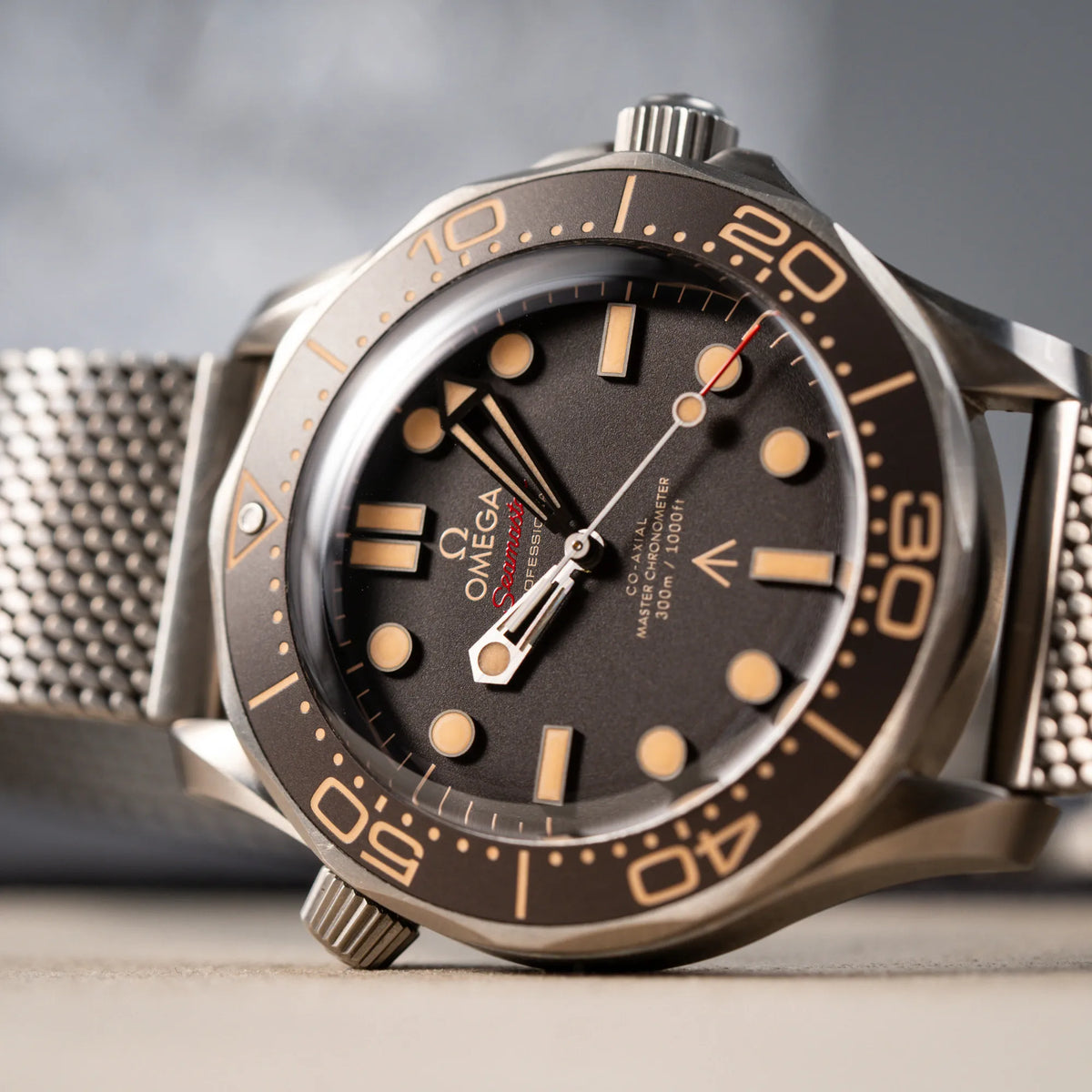 Detailaufnahme des Uhrenkopfes der Omega Seamaster 300m Diver No Time To Die Limited Edition aus Titan mit braunem Zifferblatt
