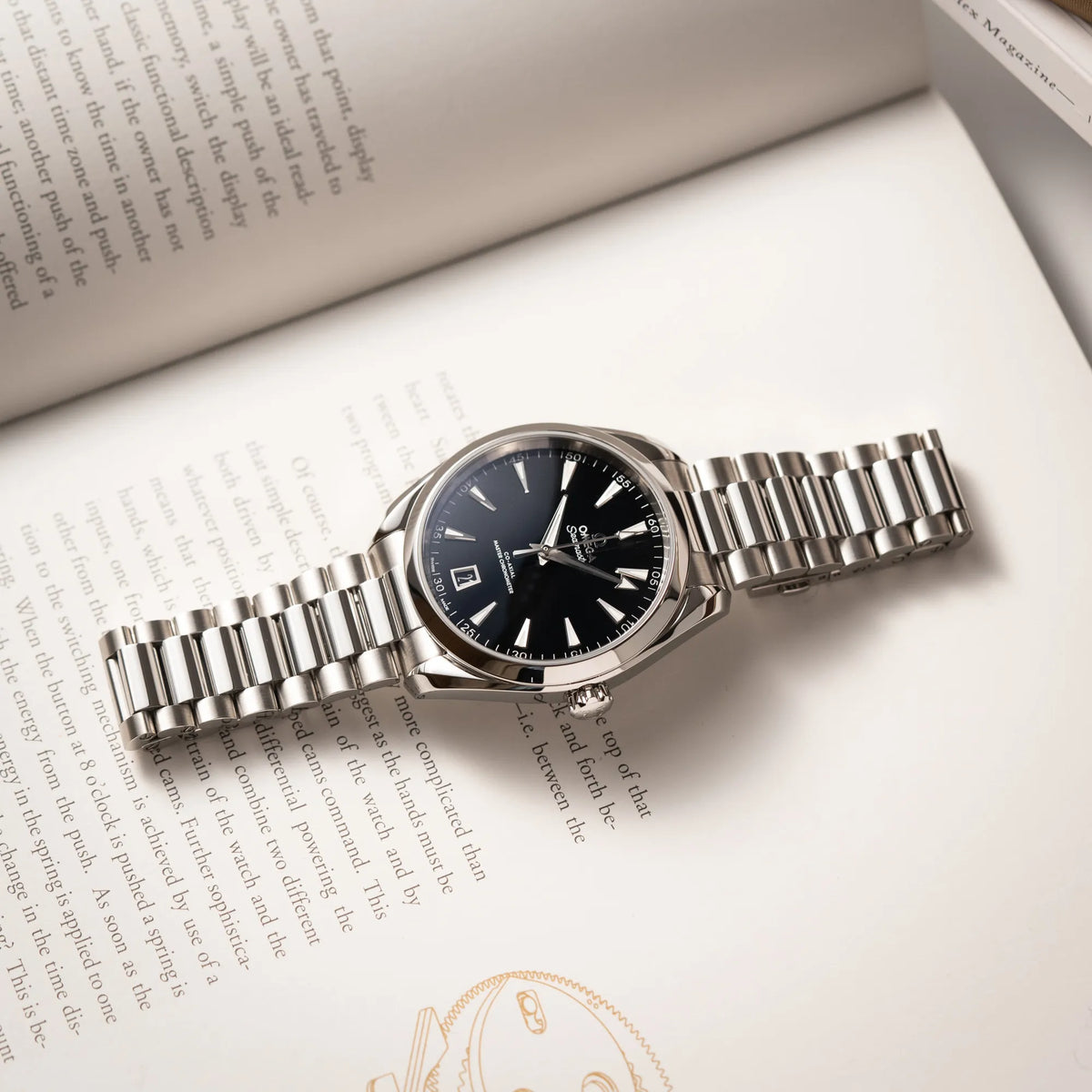 Omega Seamaster Aquaterra 220.10.41.21.01.002 mit 41 mm Gehäuse und schwarzem Lack-Zifferblatt liegt flach auf eibnem Uhrenbuch