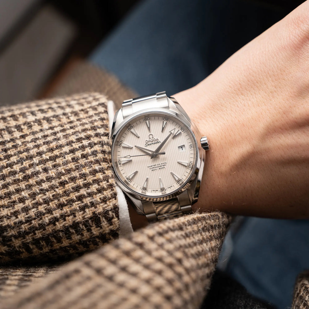 Mann trägt die Omega Seamaster Auqua Terra 150M mit 41mm-Gehäuse und einem weißen Zifferblatt mit vertikal verlaufenden Linien an seinem Handgelenk