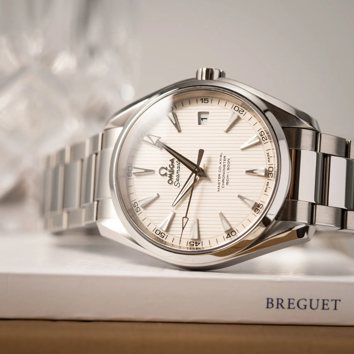 Produktfotografie als Titelbild der Omega Seamaster Aqua Terra 150M mit 41mm-Gehäuse und einem weißen Zifferblatt mit vertikal verlaufenden Linien