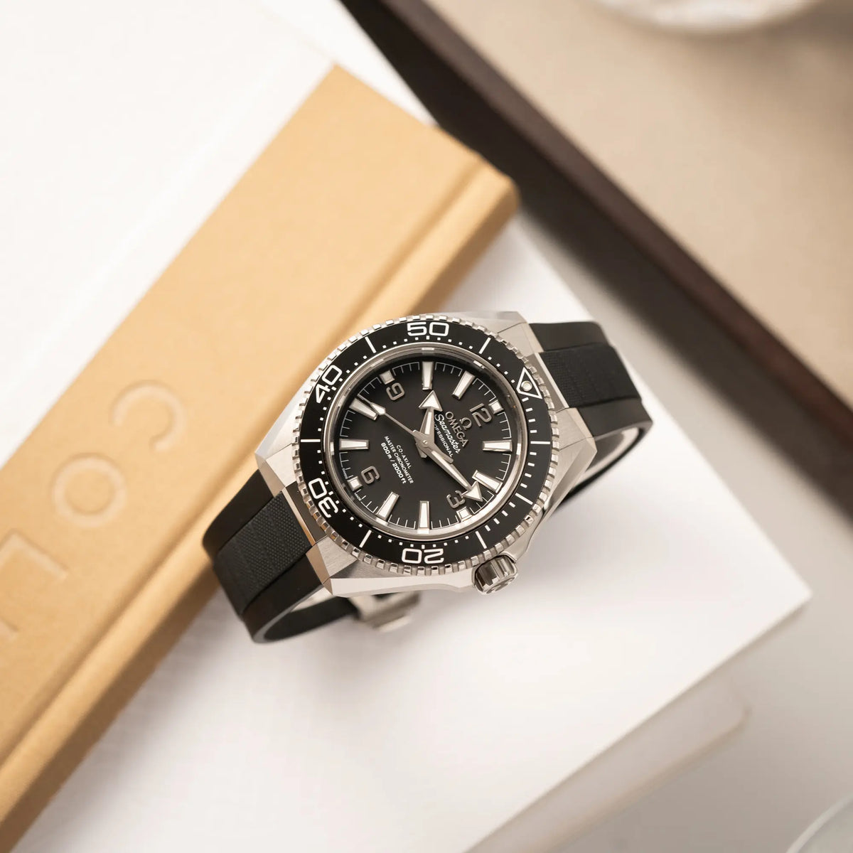 Produktfotografie als Titelbild der Omega Seamaster Planet Ocean der Referenz 217.32.42.21.01.001 (4. Generation) mit schwarzem Zifferblatt und Lünette am schwarzen Kautschuk-Armband