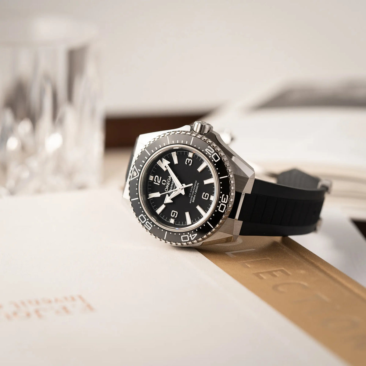 Produktfotografie der Omega Seamaster Planet Ocean der Referenz 217.32.42.21.01.001 (4. Generation) mit schwarzem Zifferblatt und Lünette am schwarzen Kautschuk-Armband