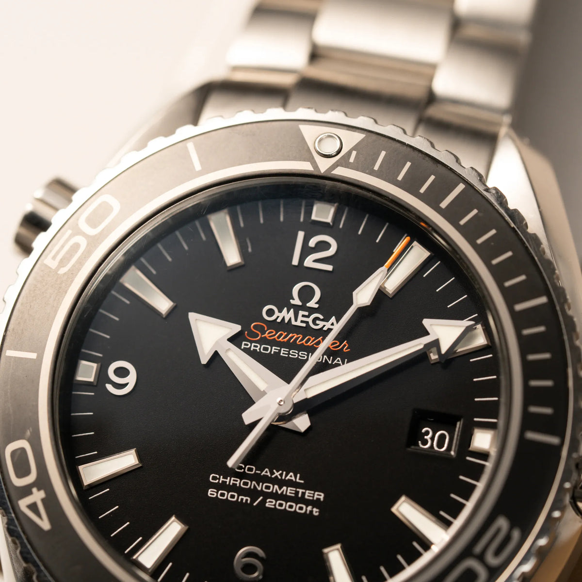 Makroaufnahme der Omega Seamaster Planet Ocean 232.30.46.21.01.001 mit 45mm Gehäuse mit Fokus auf dem  schwarzem Zifferblatt mit orangen Details