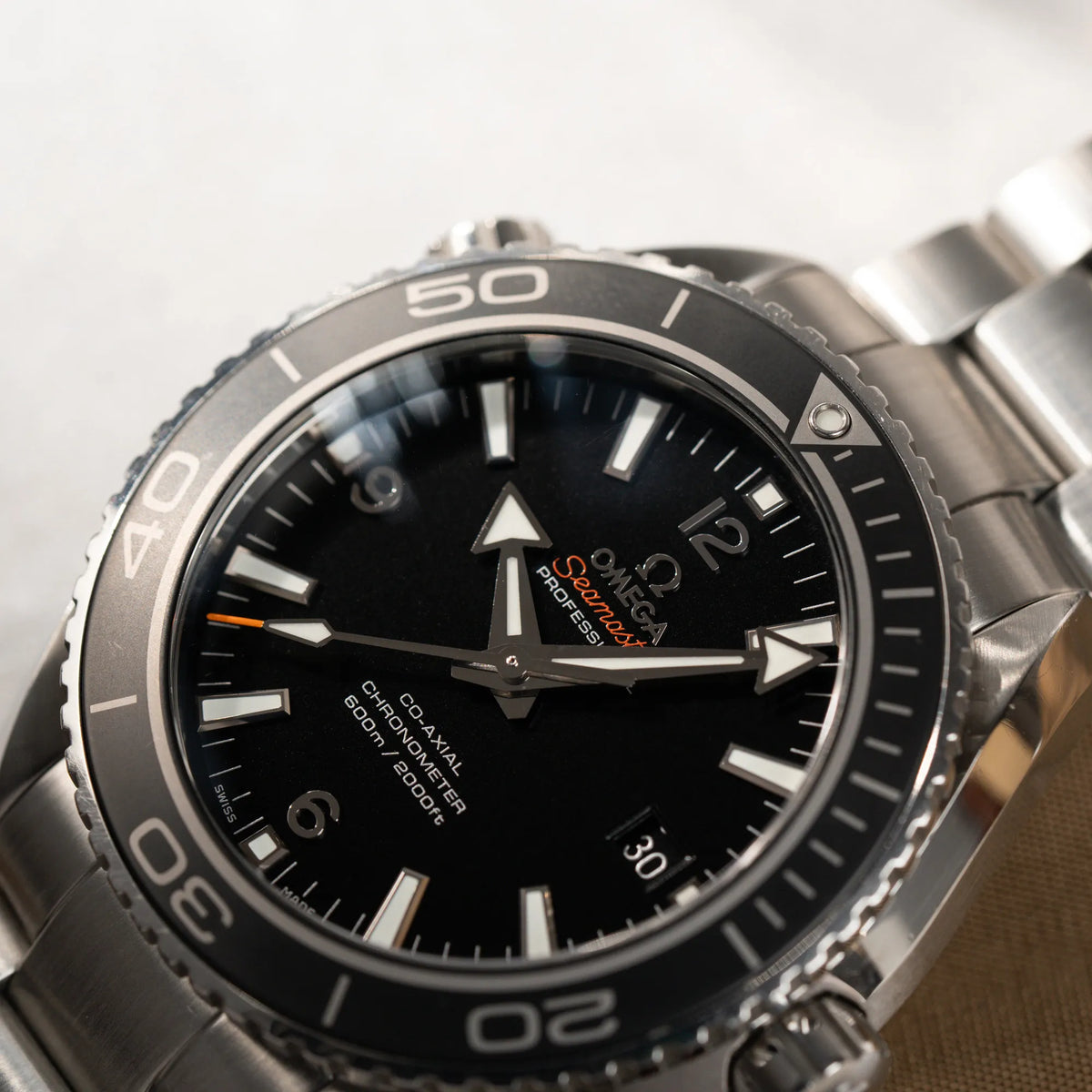 Detailaufnahme des Uhrenkopfes der Omega Seamaster Planet Ocean 232.30.46.21.01.001 mit 45mm Gehäuse und schwarzem Zifferblatt mit orangen Details